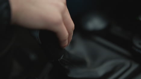 close up of motorist hand shifting gear lever in smooth expert practiced motion, wrist and knuckles moving stick through gears, highlighting driver control and mechanical precision