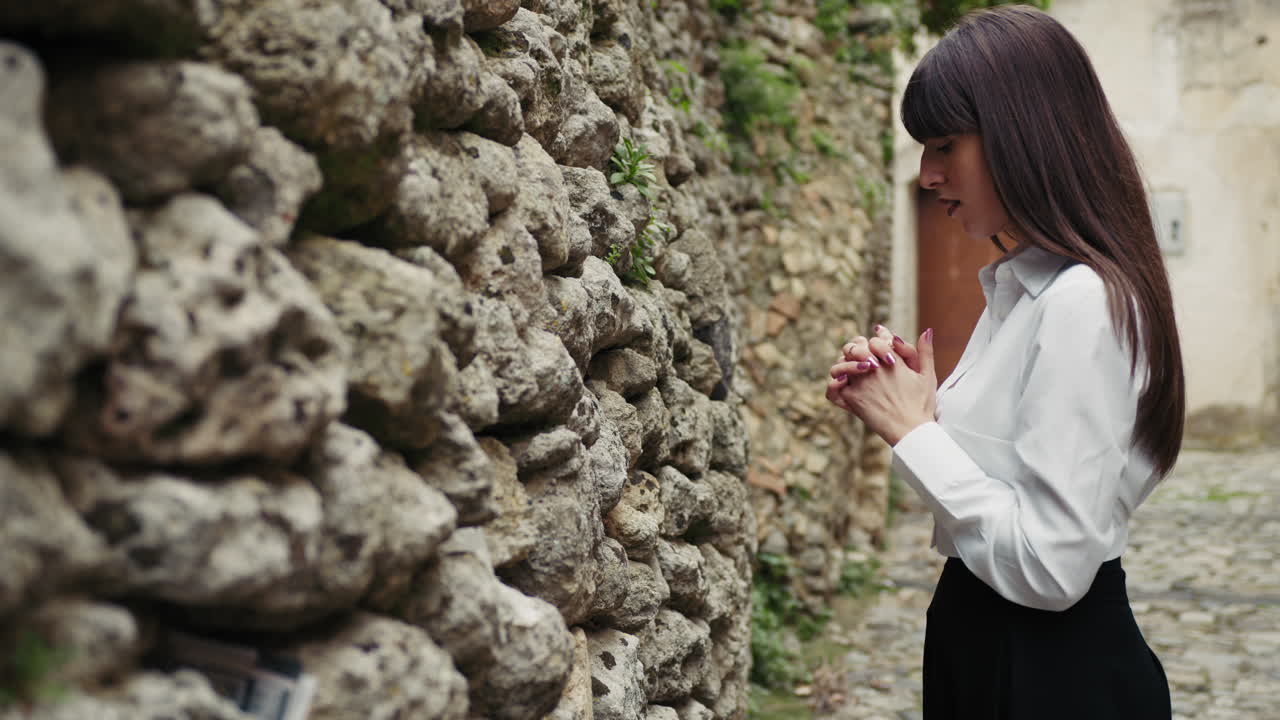Woman Praying With Passion In Front Of The Old Sacred Wall