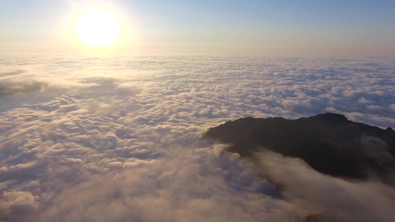 Aerial View of Mountain Peaks Above a Sea of Clouds at Sunset
