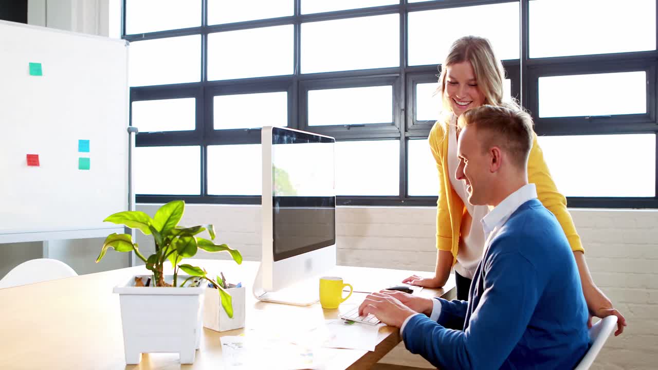 Donna d'affari e un uomo che lavorano al computer