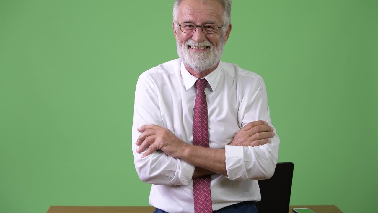 hombre de negocios barbudo y guapo contra un fondo verde.