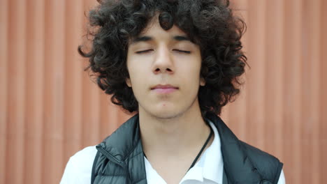 teenager with curly hair and closed eyes