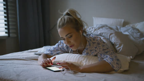 Woman-listening-to-music-in-bed