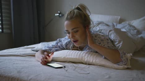 woman listening to music in bed