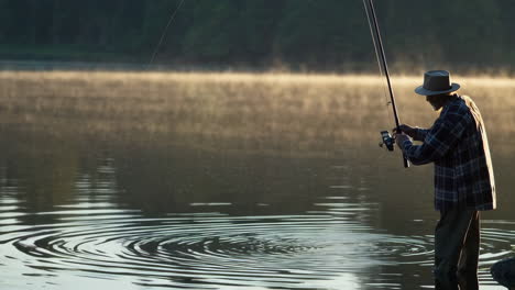 man fishing in a misty morning lake