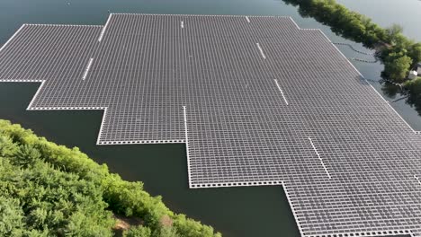 approaching aerial flight over a large floating solar panel array on a lake in new jersey