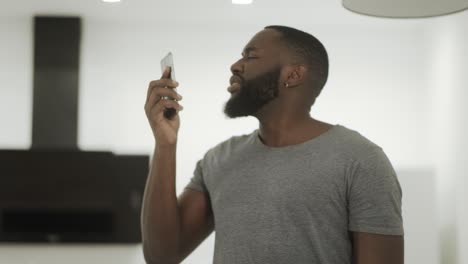 Upset-black-talking-phone-at-home-kitchen.-Disappointed-guy-finishing-phone-talk