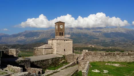 Woman-sits-in-the-fortress-of-Gjirokastra-and-enjoys-the-view-towards-the-bell-tower