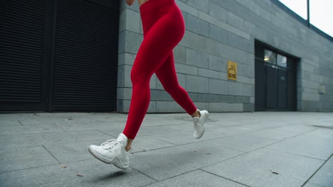 fitness woman legs running on urban street. close up runner woman legs jogging