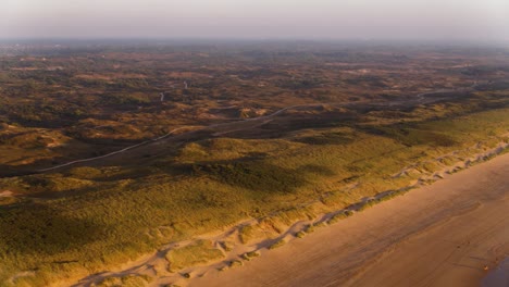 Toma-De-Drones-En-Movimiento-De-Las-Hermosas-Dunas-De-Meijendel,-Que-Se-Extiende-A-Lo-Largo-De-Una-Playa-De-Arena-Del-Sur-De-Holanda