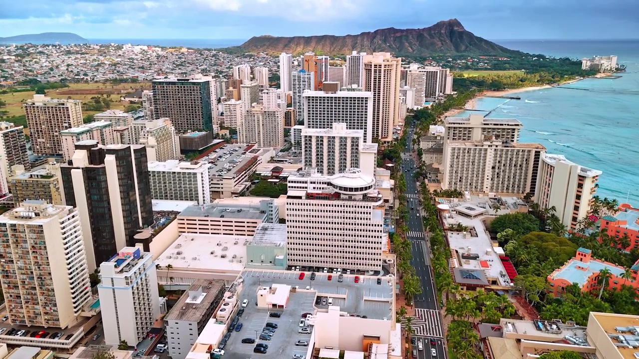 Chuyến bay phía trên các tòa nhà đa dạng của khu vực Waikiki bên bờ Thái Bình Dương. Miệng núi lửa Diamond Head ở phía sau
