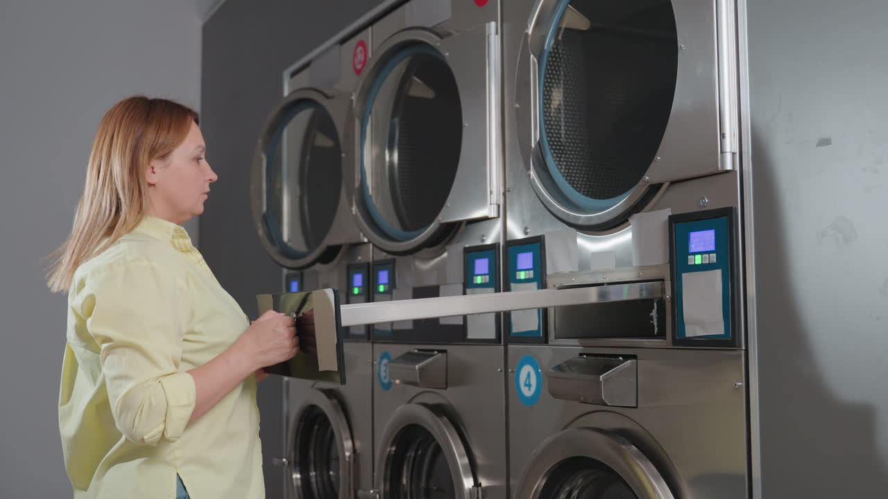Laundry owner closes industrial washer filter drawer after inserting cleaned inner filter, pushes unit back into compartment, locks with key, ensures routine maintenance in laundromat environment