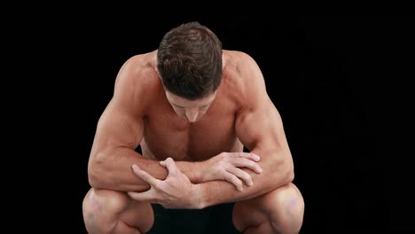 Muscular--man-with-arms-crossed-looking-down