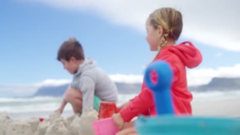 niños haciendo castillos de arena en la playa