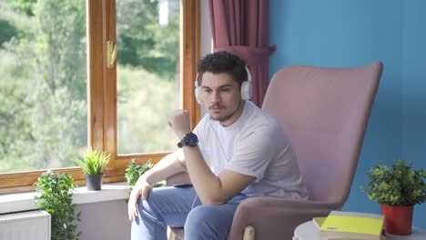hombre infeliz escuchando música con auriculares.