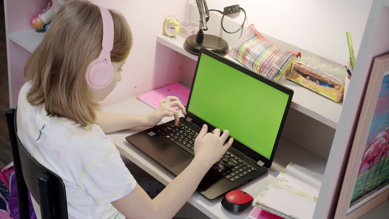 una adolescente está usando una computadora portátil en casa, video lección en línea en pantalla verde
