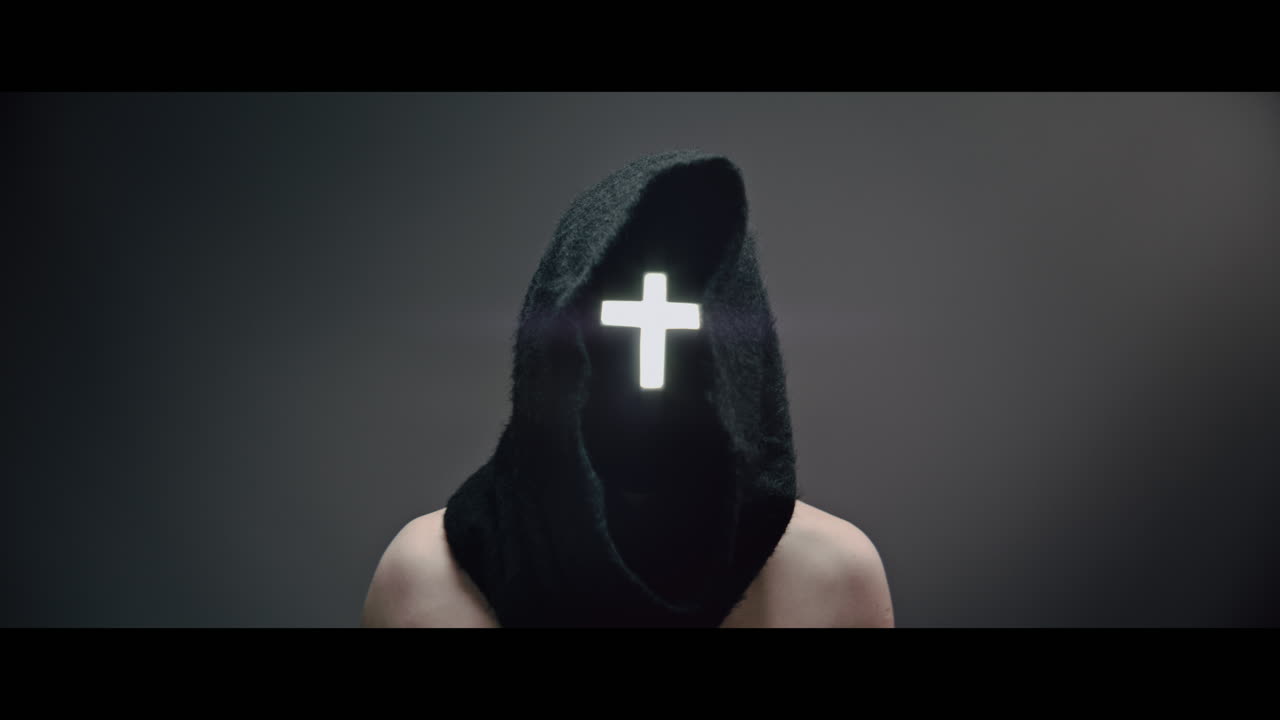 Masked man with cross of light glowing on his face rise his head