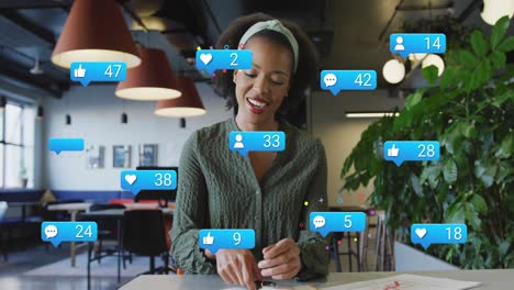 Animation-of-social-media-icons-over-african-american-woman-talking-looking-at-the-camera-at-office