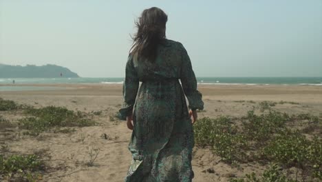 beautiful woman in a dress, beach and sea on the horizon, slow motion shot