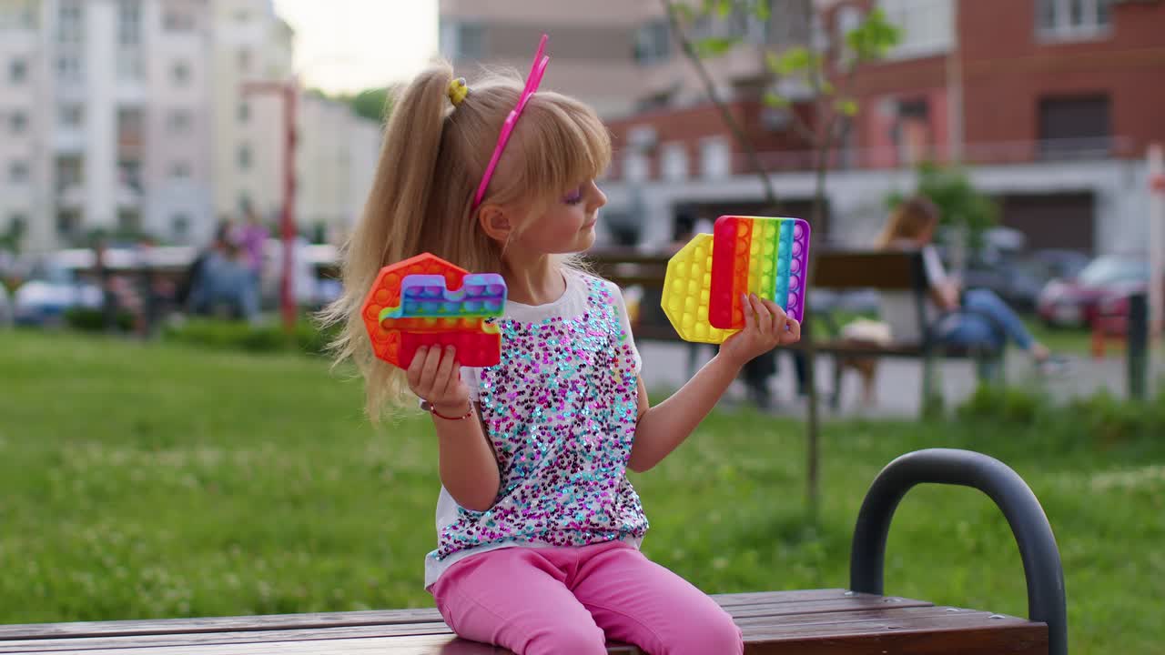 niña niña elegante y linda mostrando burbujas de pantalla táctil de silicona blandas pop it juguetes de juego sensoriales