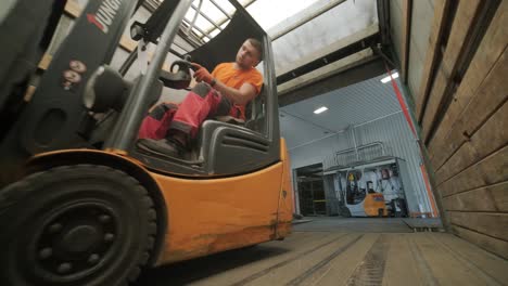 forklift driver transports packaged water bottles in warehouse