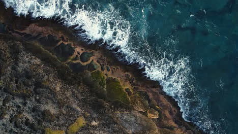 aerial pullout of cap des pins in lifou island, rugged pacific coastline cliffs