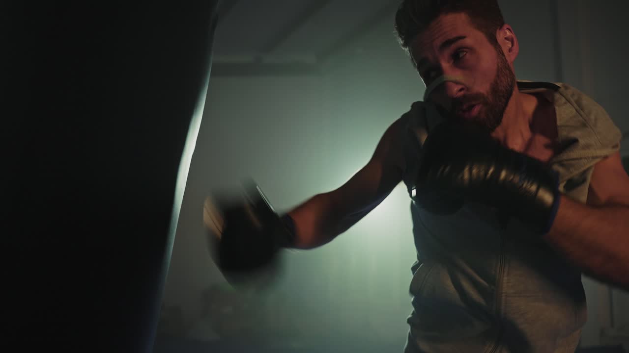 Man Punching a Boxing Bag in the Gym