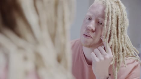 person with albinism looking in a mirror