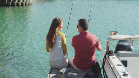 vista trasera de un hombre caucásico y su hija adolescente lado del puerto de pesca