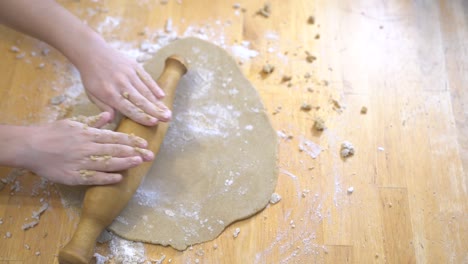 la chica despliega la masa sin gluten para la pizza o las galletas. cocinando juntos.