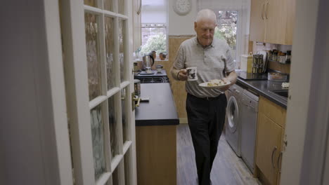 senior man having breakfast in his kitchen