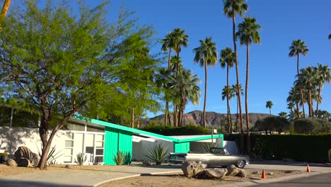 exterior establishing shot of a palm springs california mid century modern home with classic retro cars parked outside 7