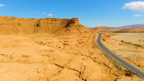 aerial shot by drone of a road in the middle of the desert, rocky mountain