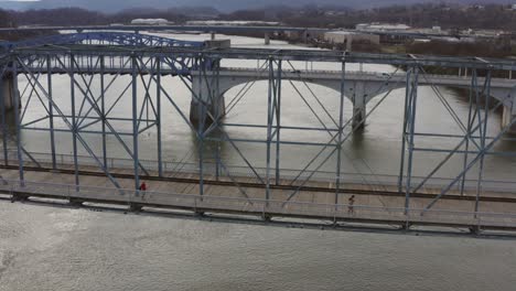 gente caminando en un gran puente peatonal sobre un río