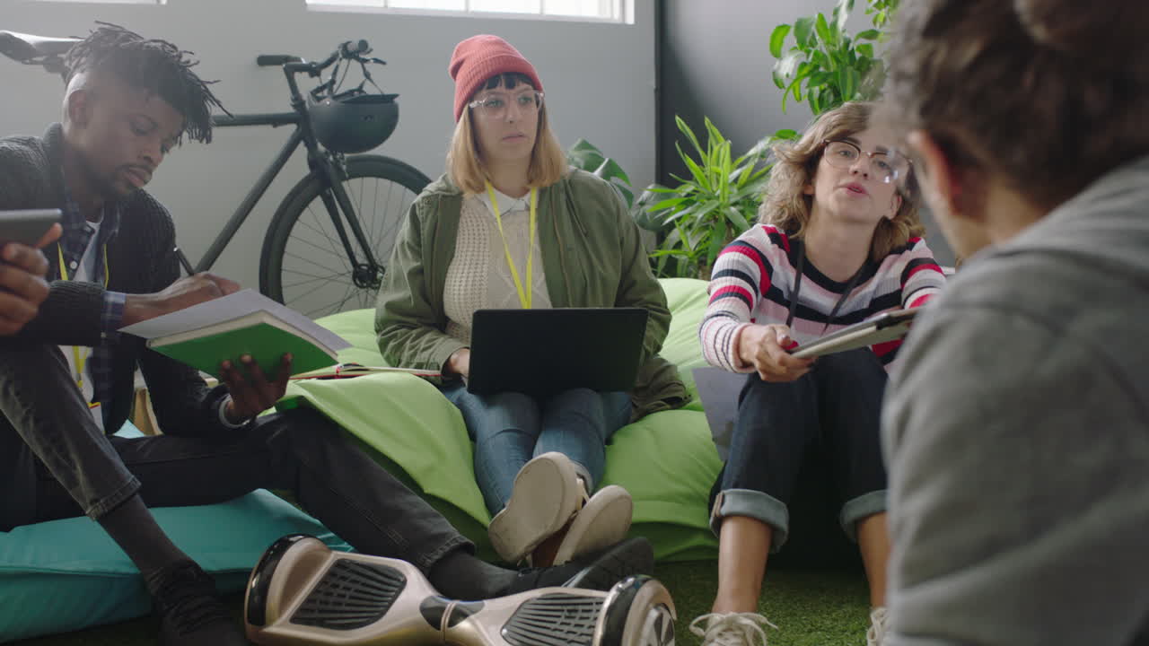 un grupo joven de estudiantes de negocios estudian juntos usando una tableta digital trabajando en un proyecto de lluvia de ideas compartiendo ideas relajándose en una oficina multiétnica