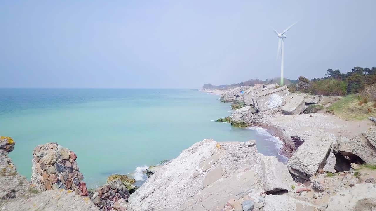 라트비아 리파야의 발트해 해변에 있는 카로스타 북부 요새에 있는 버려진 해변 요새 건물의 공중 전망, 화창한 날 잔잔한 바다, 광각 드론이 뒤로 움직이는 모습