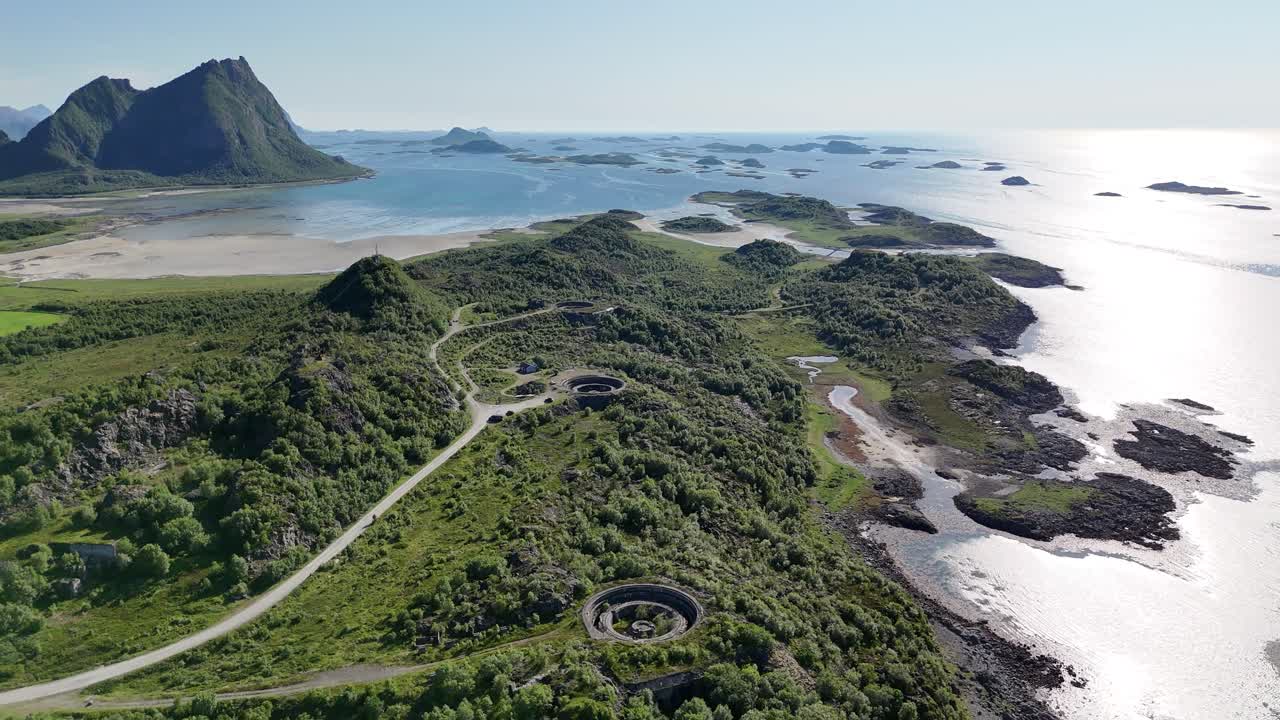 Aerial footage of Batterie Dietl on Engeløya, Norway. A historic World War II site now set on a peaceful island, surrounded by mountains and lapped by the sea