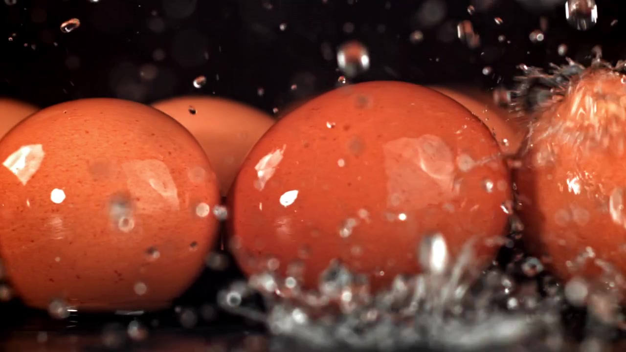 Vand sprøjter i slowmotion på friske brune æg
