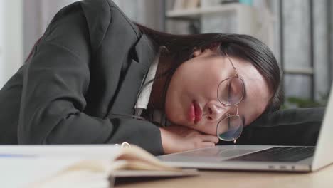 tired businesswoman sleeping on laptop