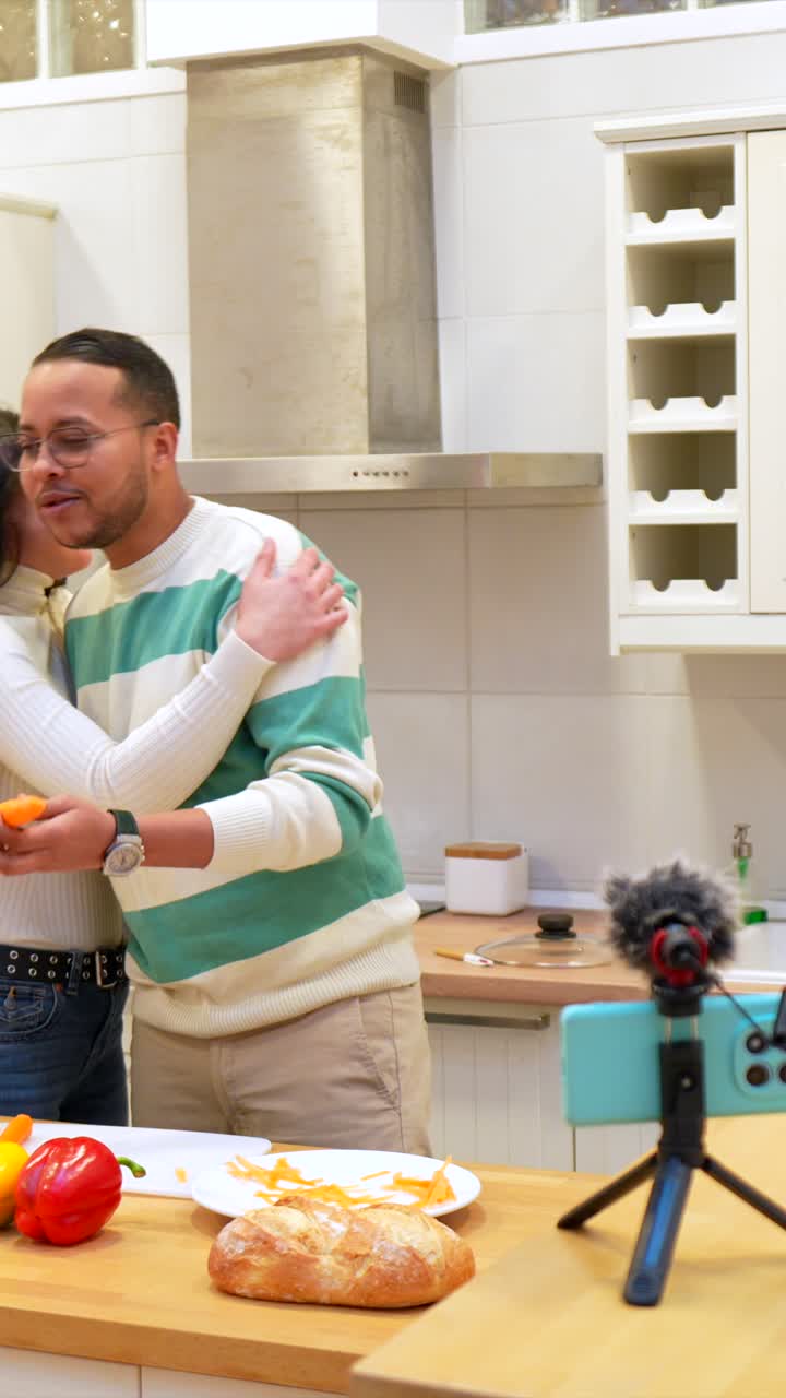 Coppia felice che registra un tutorial di cucina in una cucina moderna.