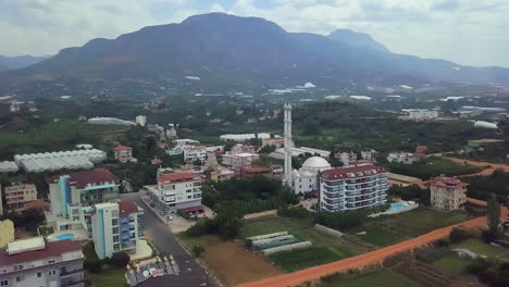 aerial view of a turkish town with mosque and mountains