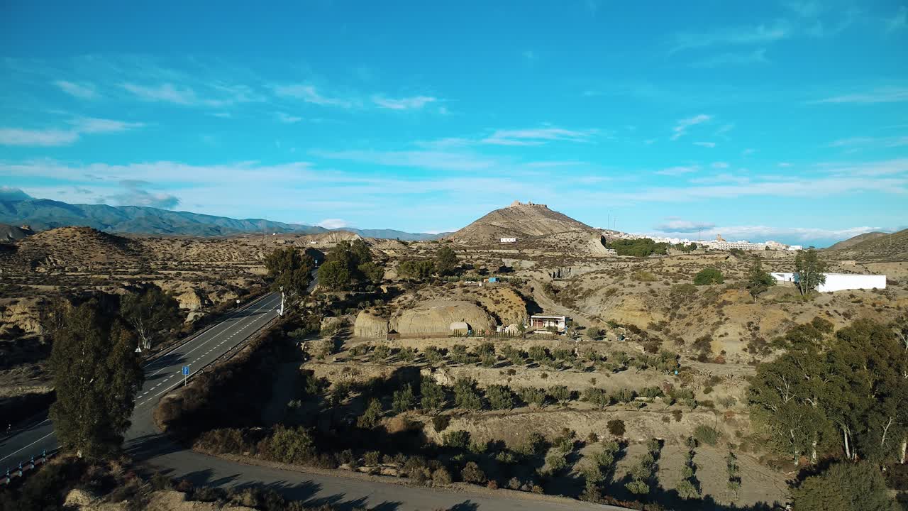 Vista aerea di un paesaggio desertico arido con strada e un villaggio distante