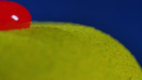 close-up of a green sphere with a red ball on top