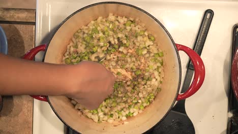 saltear cebollas y pimientos para hacer una salsa para asar pollo en el horno holandés - serie de pollo asado con vista superior