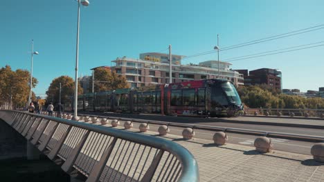 A-tram-is-moving-towards-the-city-in-the-middle-of-a-sunny-day,-Montpellier---France