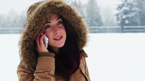 Mujer-Sonriente-Con-Chaqueta-De-Piel-Hablando-Por-Teléfono-Móvil