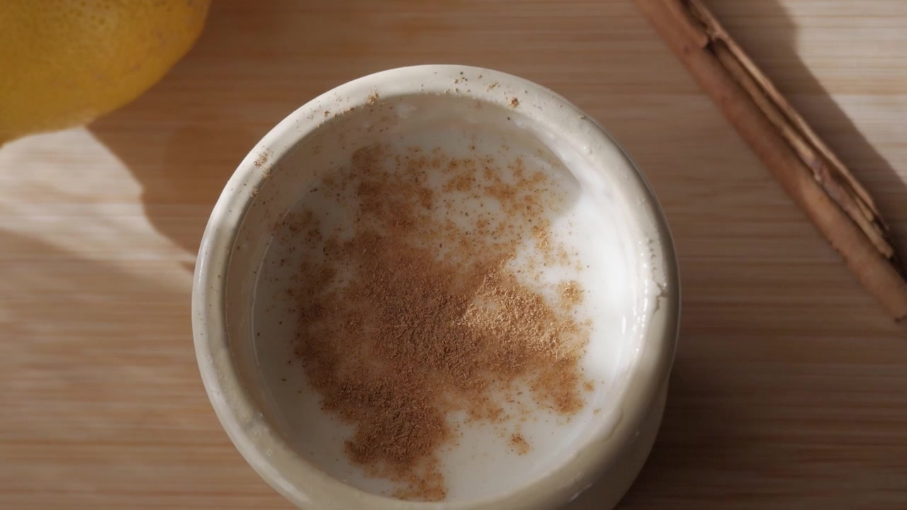 Un budino di riso cremoso guarnito con cannella, sotto una luce solare soffusa, evoca calore e comfort