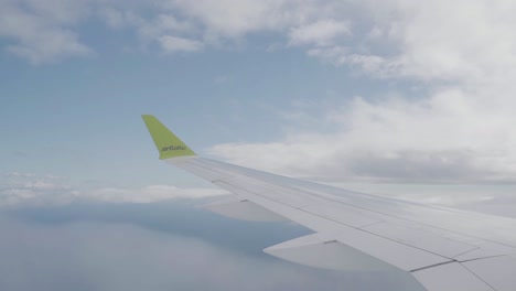 air baltic ascending through the clouds, shot from inside the cabin.