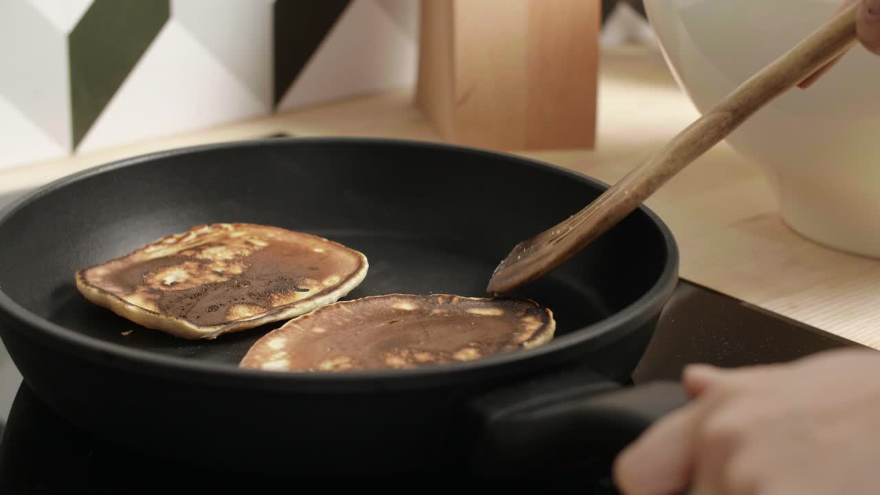 Woman's hand frying the pancakes on pan
