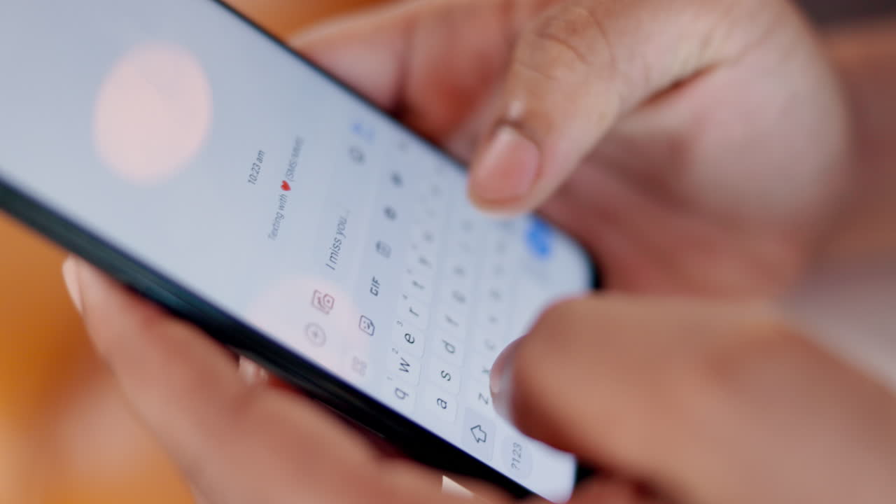 Hands typing a message on a smartphone